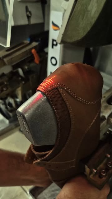 Leather shoe being finished on a machine